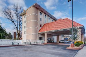 um edifício de hotel com um telhado vermelho e um parque de estacionamento em River Bend Inn - Pigeon Forge em Pigeon Forge