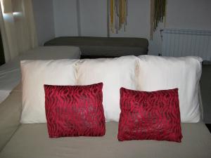 two red pillows sitting on top of a bed at Apartments Luna 19 in Alcañiz