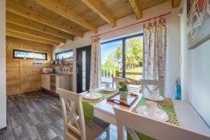 uma cozinha e sala de jantar com mesa e cadeiras em Domki Morskie Tarasy em Jastrzebia Gora