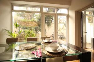 a dining room with a glass table and a large window at The Bromptons, Luxury South Kensington Apartment in London