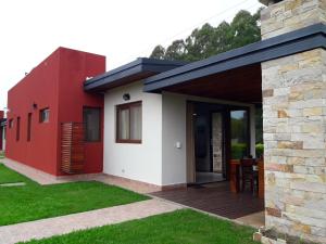 Casa roja y blanca con terraza de madera en Aires del Norte, en Federación
