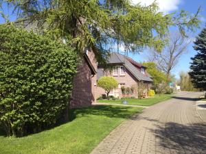 una casa de ladrillo con un árbol y una entrada en Villa An Der Au, en Lemkendorf