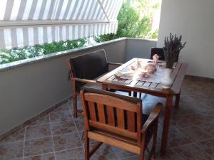 a wooden table and two chairs on a porch at Apartments M&B in Podstrana