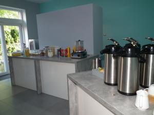 kuchnia z dwoma dużymi metalowymi czajnikami na ladzie w obiekcie Gdanziger Dom w Gdańsku