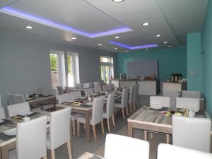 une salle à manger avec des tables en bois et des chaises blanches dans l'établissement Gdanziger Dom, à Gdańsk