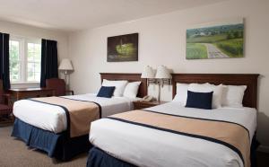 una habitación de hotel con 2 camas y una silla en Travelers Rest Motel en Intercourse