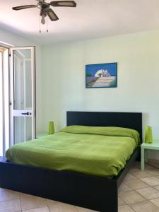 a bedroom with a green bed with a ceiling fan at Casa Anter Santa Maria di Leuca in Leuca