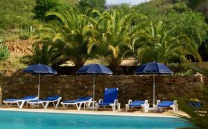 a group of chairs and umbrellas next to a pool at Terra das Delicias in Morenos