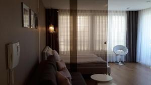 uma sala de estar com um sofá e uma cama em Apartament Aria Studio na Cracóvia