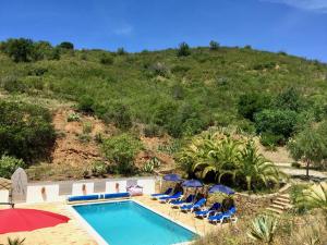 an outdoor swimming pool with chairs and umbrellas at Terra das Delicias in Morenos +9 photos