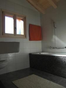 baño con bañera y ventana en Chalet Griffon, en Nendaz
