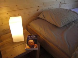 a book on a table next to a bed with a lamp at Chalet Griffon in Nendaz