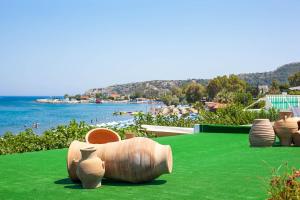 a group of vases sitting on top of a green lawn at Dimitra Boutique Rooms in Faliraki
