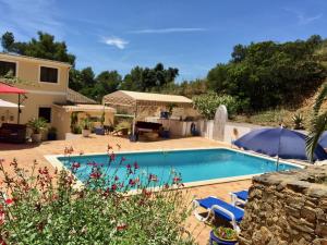 a villa with a swimming pool and a house at Terra das Delicias in Morenos