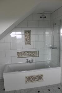 a bath tub in a bathroom with white tiles at The Eagle House Hotel in Launceston