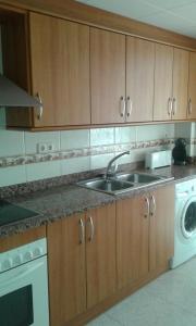 una cocina con fregadero y lavadora en La Rambleta, en L'Ametlla de Mar 2 fotos más