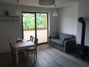 a living room with a table and a couch at Apartament Danusia in Szczawnica