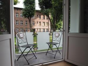 two chairs sitting on a balcony looking out a window at Grand Tourist Simple Rest Apartments in Gdańsk