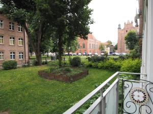 een balkon met een tuin met bomen en gebouwen bij Grand Tourist Simple Rest Apartments in Gdańsk