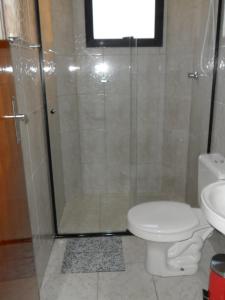 uma casa de banho com um chuveiro, um WC e um lavatório. em Pousada Olga em Solemar