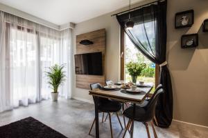 Apartament di Mare في غدانسك: غرفة طعام مع طاولة وكراسي ونافذة