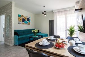 a living room with a table and a blue couch at Apartament di Mare in Gdańsk