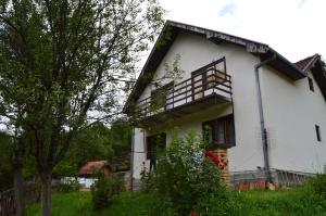 a white house with a balcony on the side of it at Apartment Sijakovic in Mokra Gora
