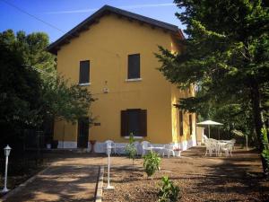 a yellow house with tables and chairs in front of it at Le Case del Parco in Peschici