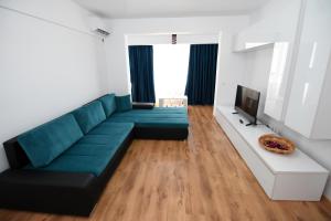 ママイア・ノルドにあるMusic Apartment Mamaia Nordのリビングルーム(青いソファ、テレビ付)
