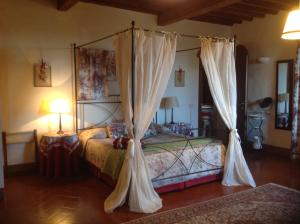 a bedroom with a bed with curtains on it at La Canonica Di San Michele in Monteriggioni