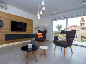 Apartments Villa Castello في قشتيلا: غرفة معيشة مع كرسيين وتلفزيون بشاشة مسطحة