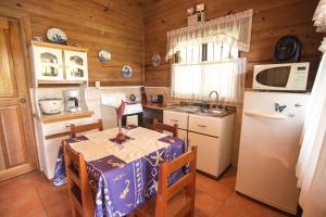 a small kitchen with a table and a refrigerator at Casa Marcellino Lodge in Cahuita
