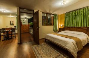 a bedroom with a bed and a table and a kitchen at Hotel San Francisco De Quito in Quito