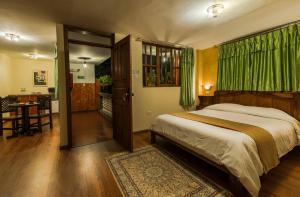 ein Schlafzimmer mit einem Bett und einem Tisch sowie eine Küche in der Unterkunft Hotel San Francisco De Quito in Quito