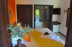 Un dormitorio con una cama con una planta. en Pousada Caminho do Sol, en Arraial do Cabo