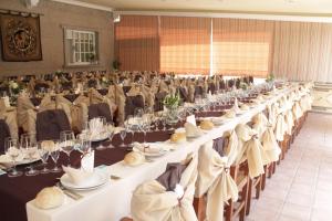 a large banquet hall with white tables and chairs at Hotel San Carlo in Coirón