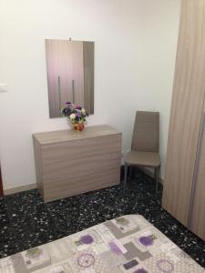 una camera da letto con cassettiera, specchio e sedia di B&B AL CANDIANO a Ravenna