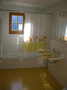 baño con bañera, lavabo y ventana en Landhaus Servus, en Viehhofen
