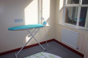 um quarto com uma mesa azul num quarto com uma janela em Renshaw Guest House em Liverpool
