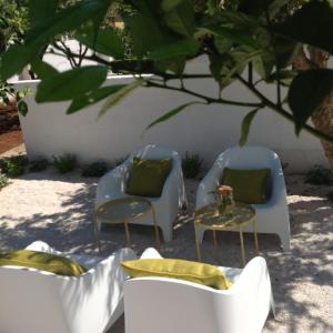 two chairs and a table under a tree at Corte dei melograni-Suite familiare-zona Ostuni in Montalbano +15 photos