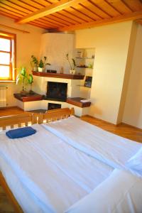 Vila Kopa Nida في نيدا: سرير أبيض كبير في غرفة بها موقد