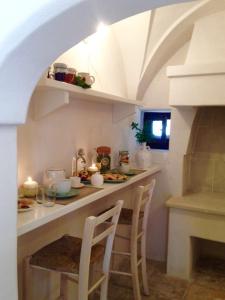 a kitchen with a counter with chairs and a fireplace at Corte dei melograni-Suite familiare-zona Ostuni in Montalbano