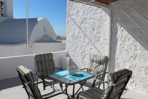 a table and four chairs on a balcony at Studios Betty in Plaka Milou
