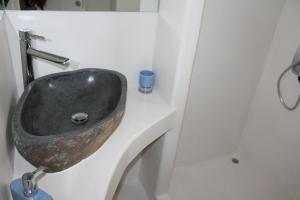 a bathroom with a stone sink on a white counter at Studios Betty in Plaka Milou