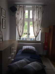 a bed with two pillows in a room with a window at Apt nr 3 - cogito.home - Marina in Gdańsk