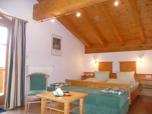 a bedroom with a bed and a table and chairs at Landhaus Servus in Viehhofen