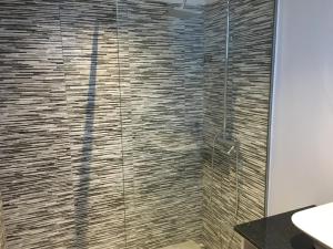 Un baño con ducha con puerta de cristal. en Villa Pinheira II, en Estreito da Calheta 33 fotos más