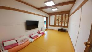 a living room with couches and a flat screen tv at Bukchon Sosunjae Guesthouse in Seoul