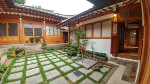 a courtyard of a house with grass and plants at Bukchon Sosunjae Guesthouse in Seoul