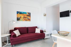 a living room with a red couch and a table at Niovi Seaside Suites in Kissamos